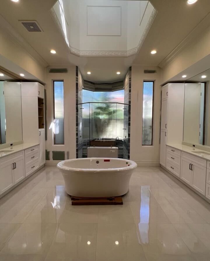 Master bathroom with a freestanding tub in front of a glass shower enclosure fitted with obscure privacy glass